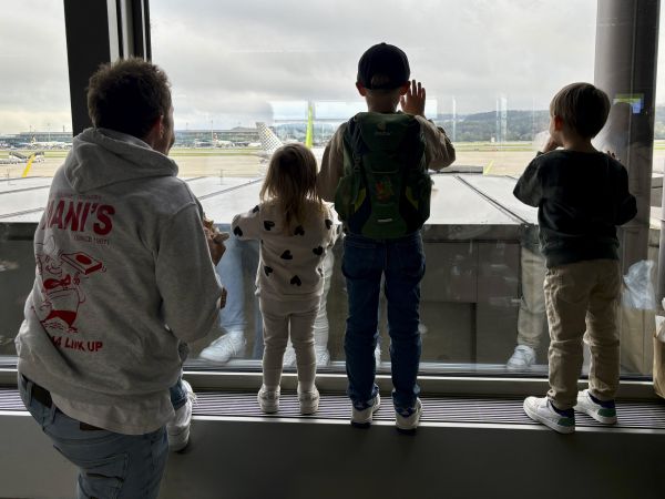Raphael schaut mit seinen Kinder aus dem Fenster am Flughafen