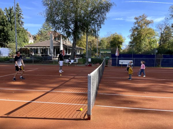 Kinder spielen gemeinsam Tennis