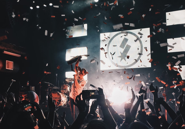 Stimmungsbild einer jubelnden Menschenmenge im Konfettiregen an einem Konzert